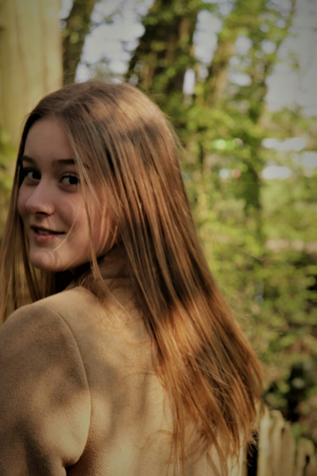 Portrait of a young woman with light brown hair smiling